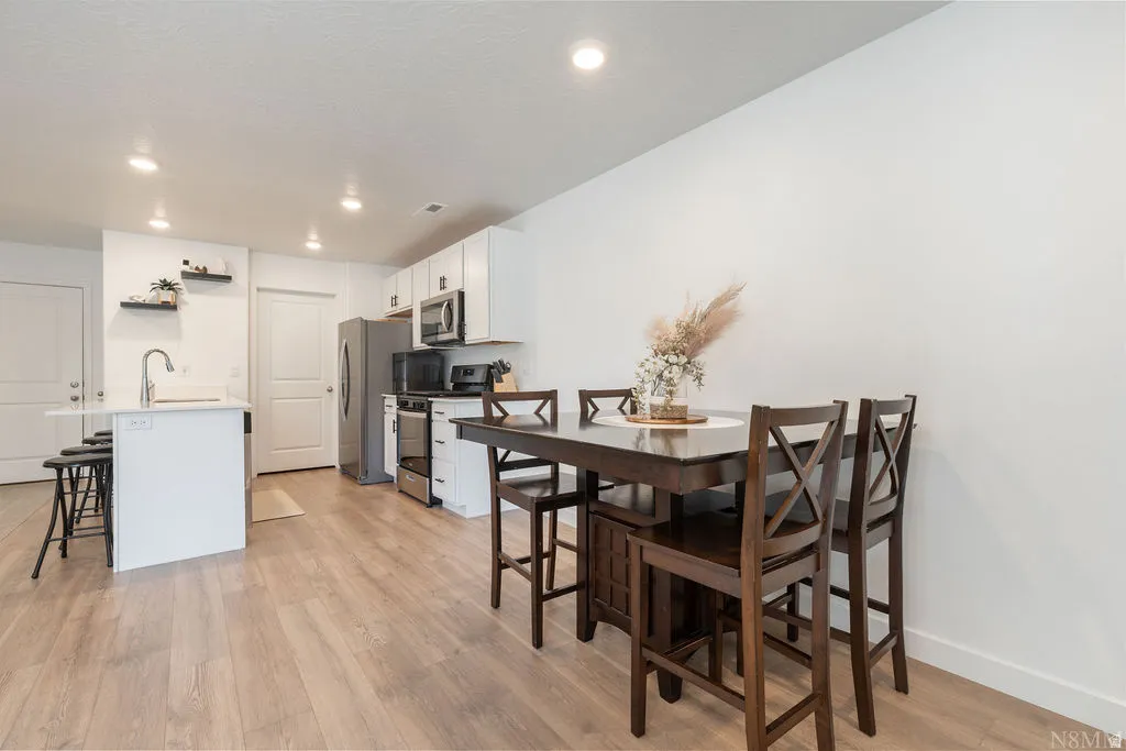 Open-concept kitchen and dining area featuring light wood-finish flooring