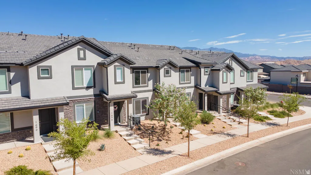 Multi-level townhome featuring a stucco exterior with stone accents and dark trim