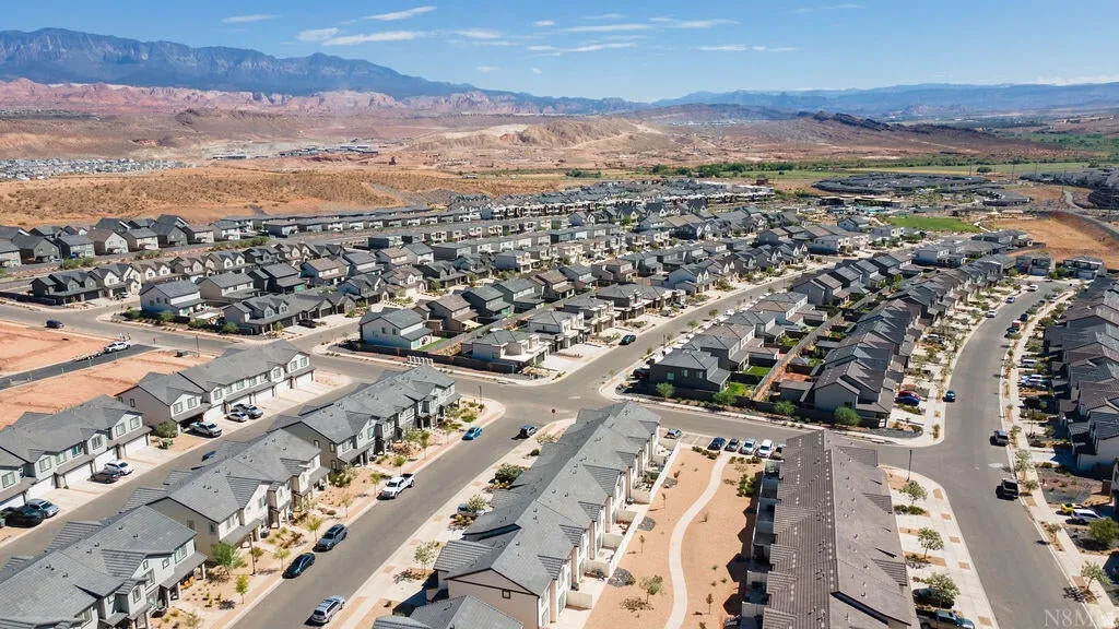 Expansive residential community featuring a mix of detached homes and townhomes with gray roofing