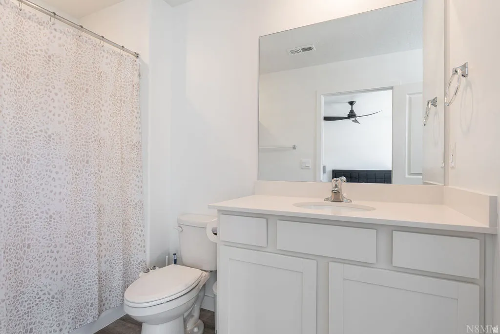 Bathroom featuring a white vanity with an integrated sink, polished chrome faucet, and a large wall-mounted mirror