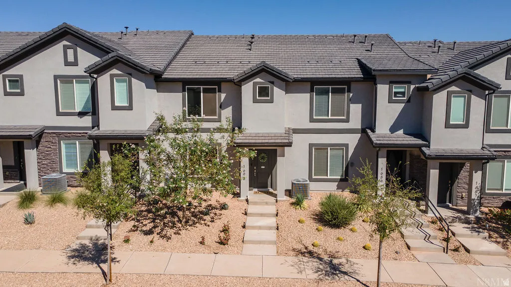 Multi-story stucco exterior featuring stone accents and dark trim
