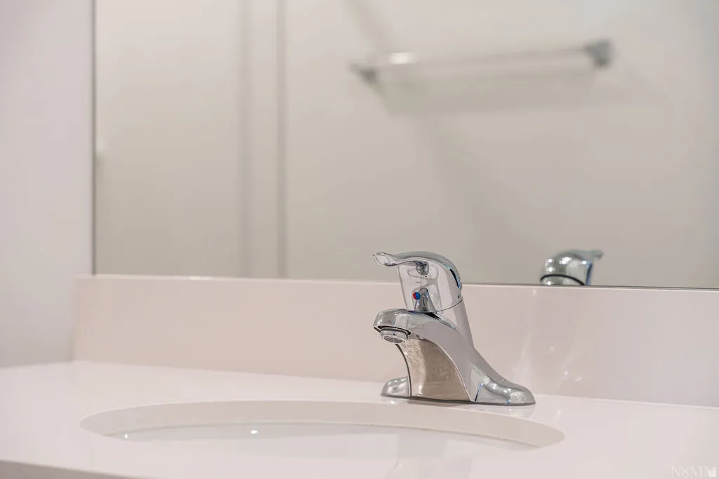 Integrated sink and countertop featuring a chrome single-handle faucet, a matching backsplash, and a large mirror