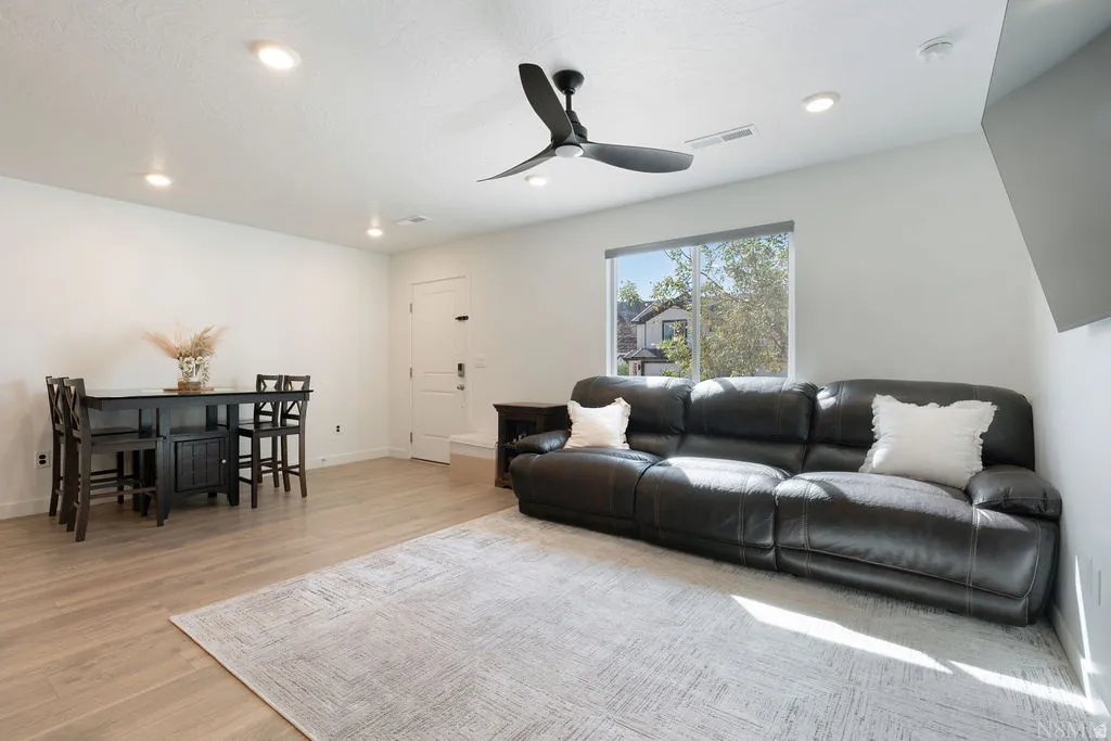 Open concept living area featuring wood-finish flooring, recessed lighting, and a ceiling fan
