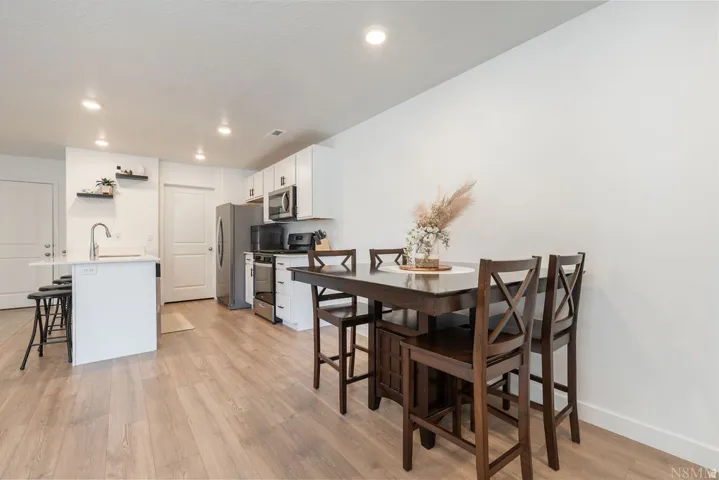 Open-concept kitchen and dining area featuring light wood-finish flooring