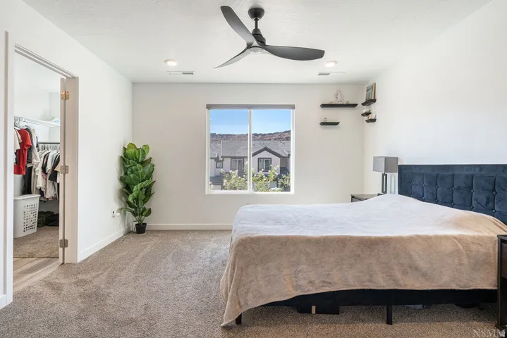 Carpeted bedroom featuring a large window, a ceiling fan with integrated lighting, and recessed lighting