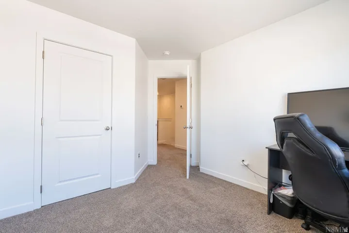 Neutral-toned carpet flooring and bright white walls