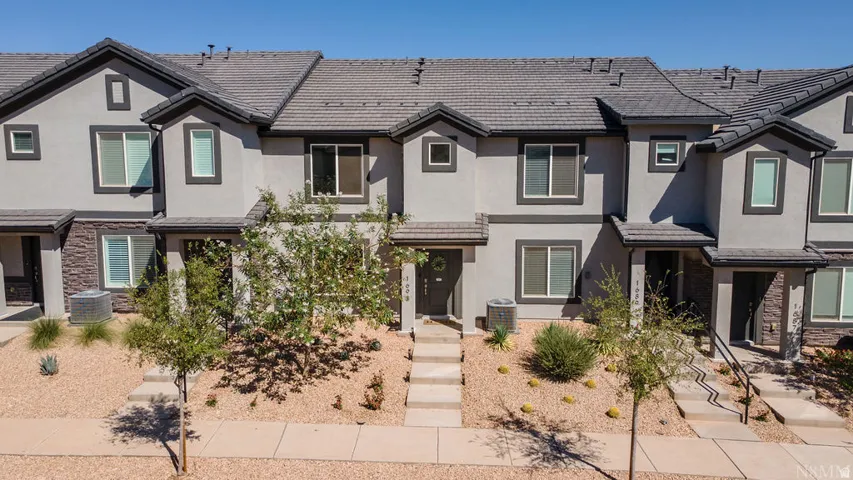 Multi-story stucco exterior featuring stone accents and dark trim