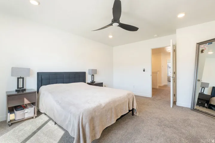 Spacious bedroom featuring neutral carpeting, recessed lighting, and a modern ceiling fan