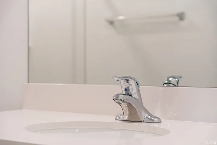 Integrated sink and countertop featuring a chrome single-handle faucet, a matching backsplash, and a large mirror