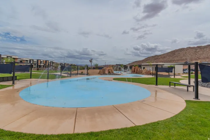 Water feature with integrated fountains, surrounded by concrete paving and manicured lawns