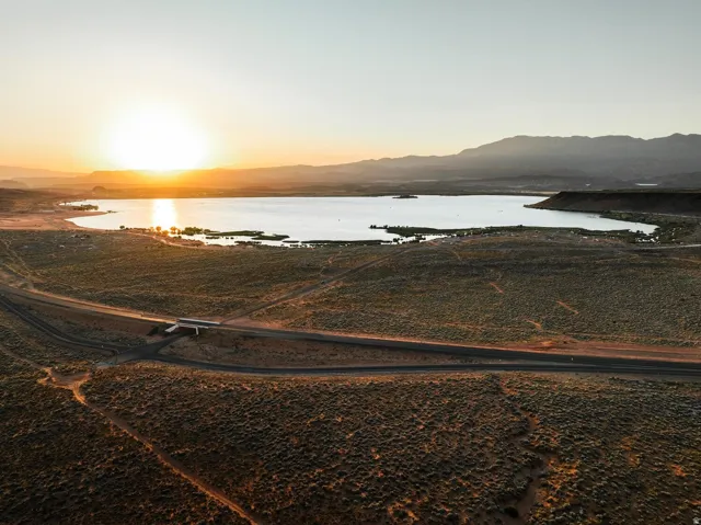 Expansive aerial landscape featuring a large lake, surrounding desert terrain, and distant mountains