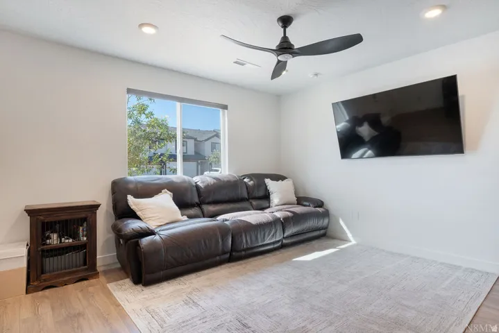 Room featuring wood-finish flooring, recessed lighting, and a ceiling fan