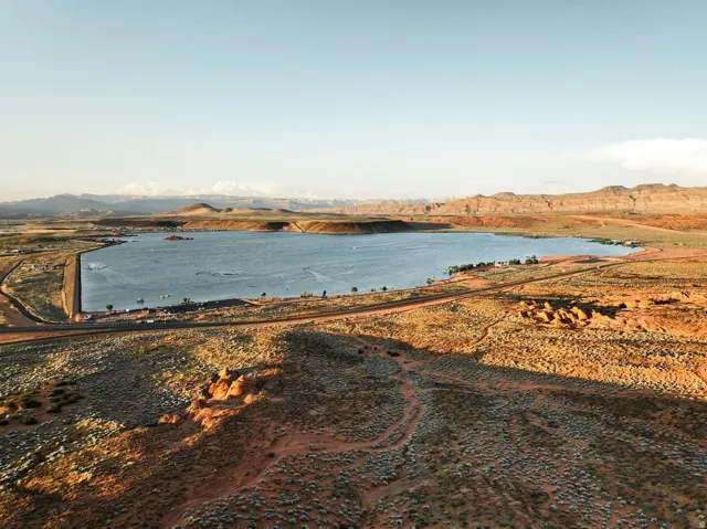 Expansive lake with a concrete dam and surrounding desert landscape