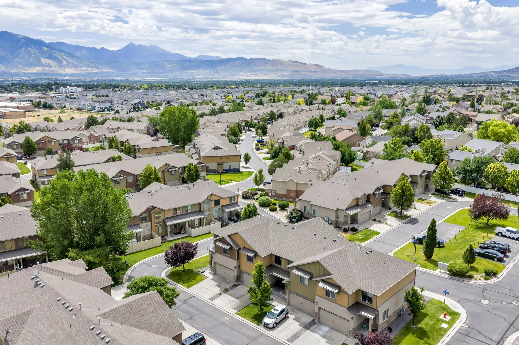 Expansive residential community featuring a variety of multi-story homes with attached garages, pitched shingle roofs, and mature landscaping