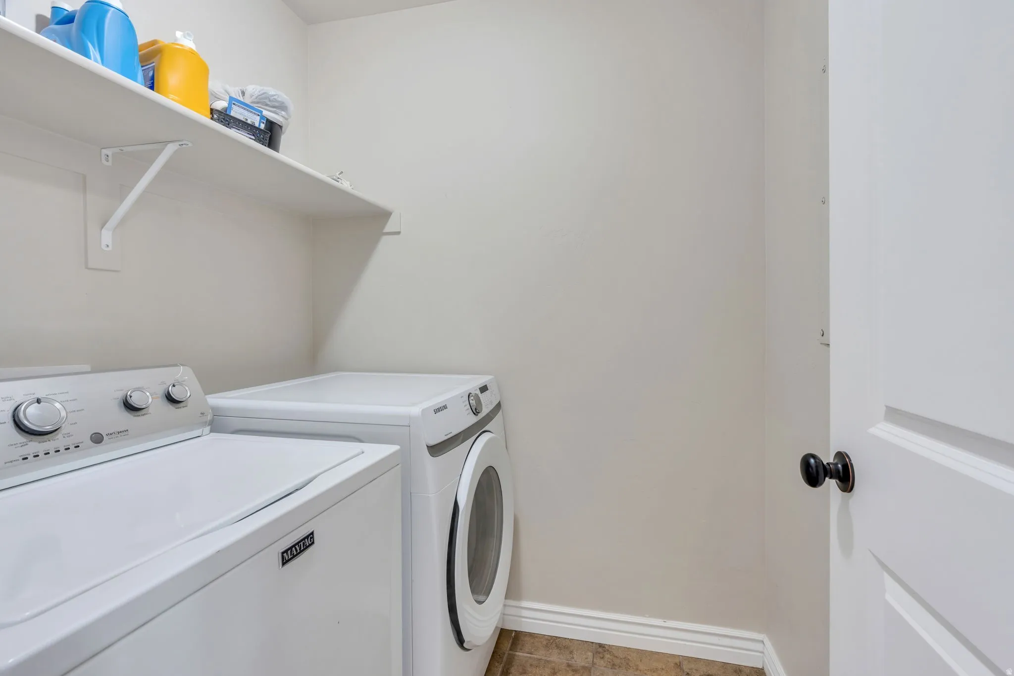 Dedicated laundry area featuring a shelf, white walls, and wood-finish flooring