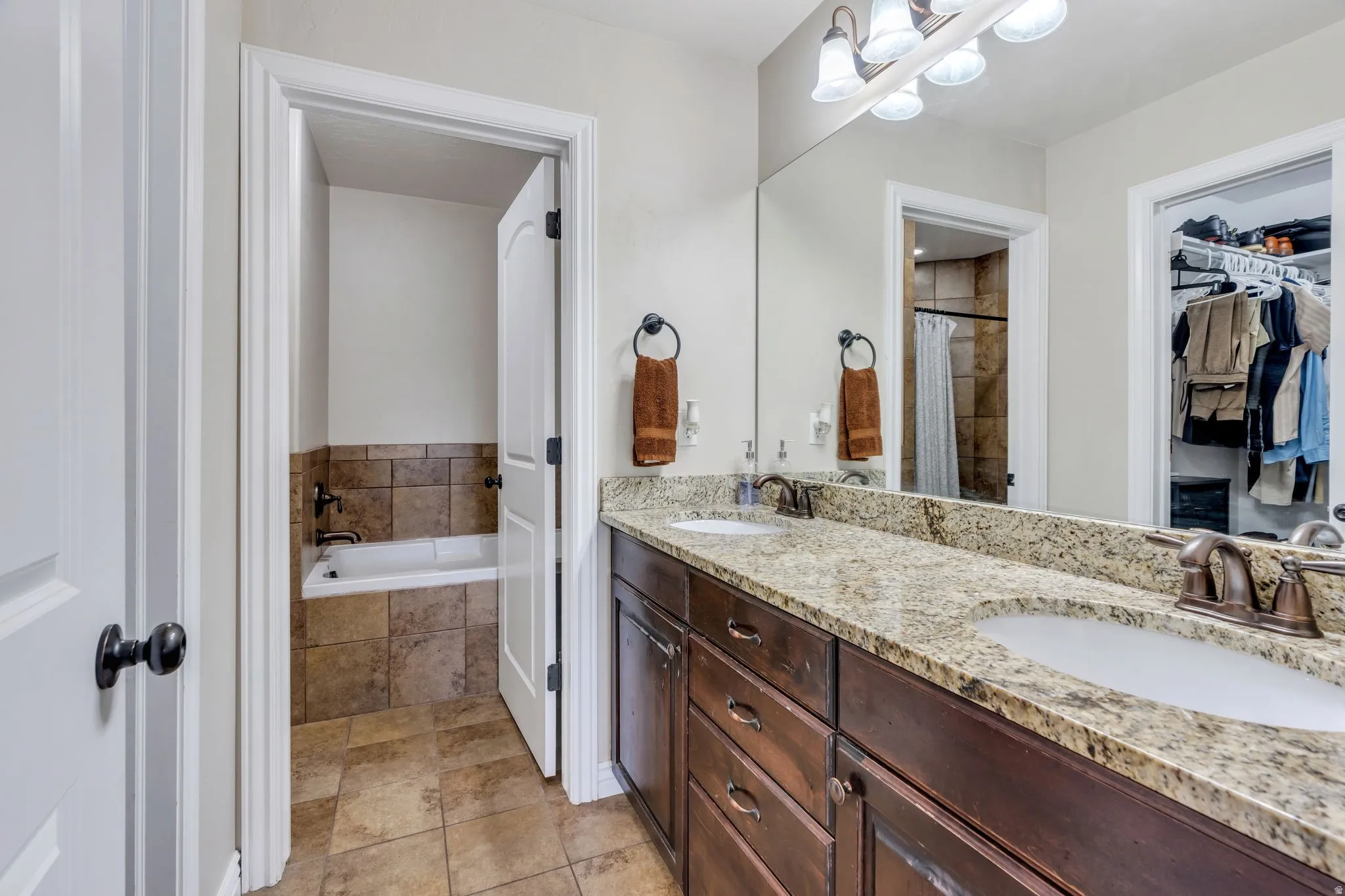 Dual vanity with granite countertop, integrated sinks, and bronze-finish fixtures