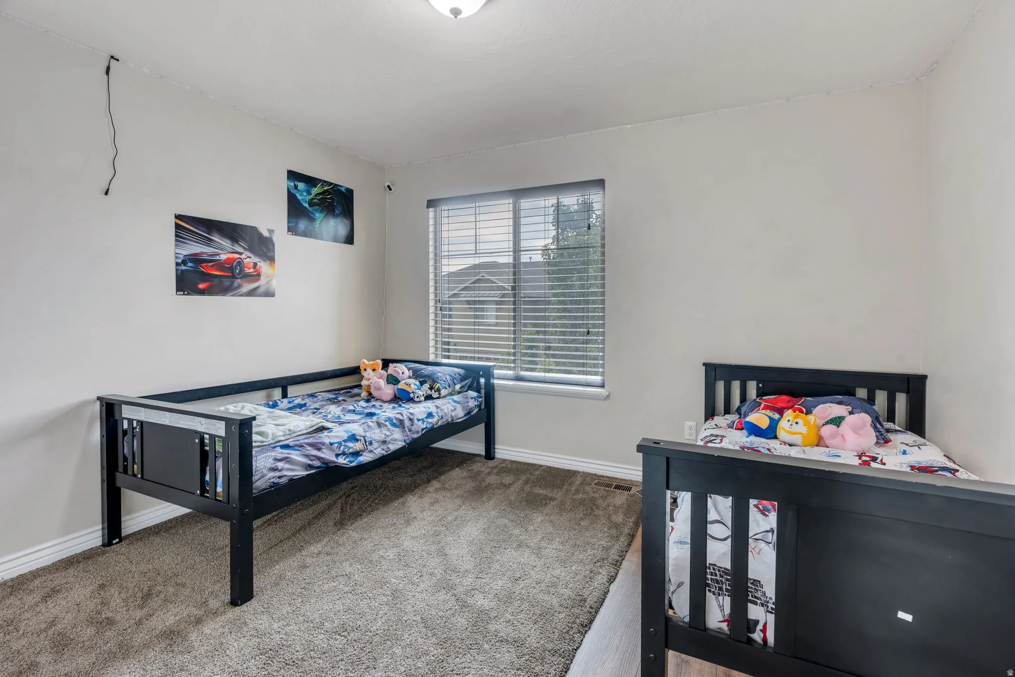 Carpeted room with a window featuring horizontal blinds