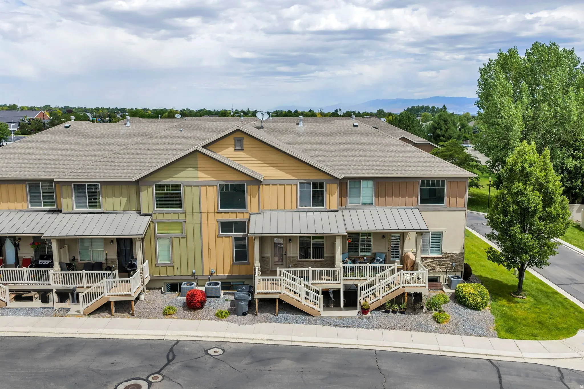 Multi-level townhome exterior featuring stone accents and horizontal siding