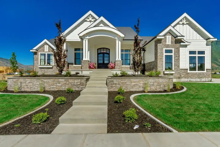 Contemporary home with white siding and stone veneer accents