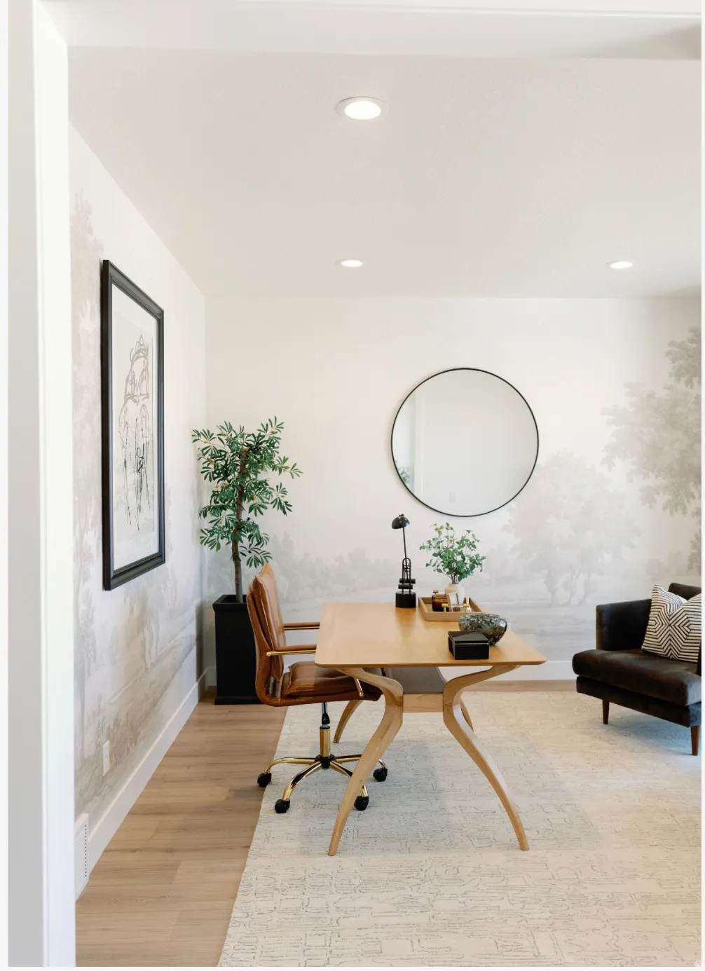 Recessed lighting illuminates this versatile room, featuring light wood-finish flooring and a decorative wall treatment