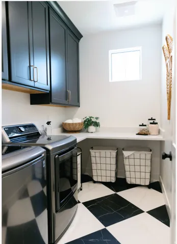Black and white checkerboard flooring provides a striking foundation for this utility space