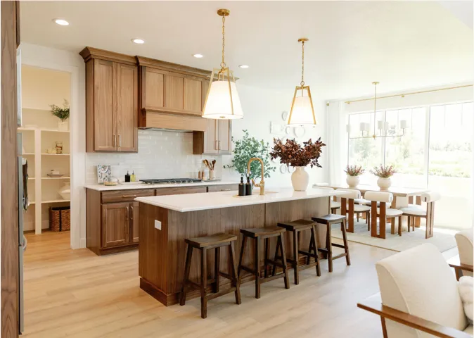 Open-concept kitchen featuring an island with counter seating, hardwood cabinetry, white subway tile backsplash, and light wood-finish flooring