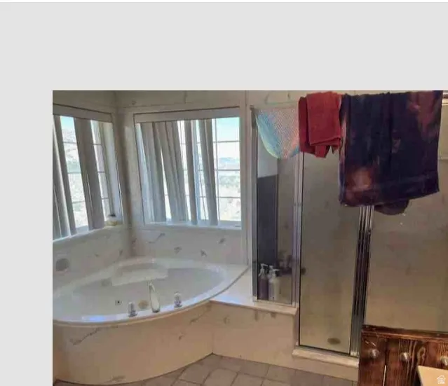 Corner soaking tub with a tiled surround, framed by multiple windows