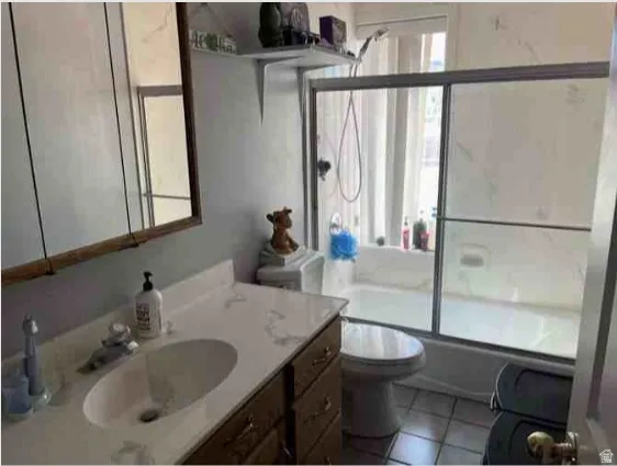 Bathroom featuring a vanity with a white countertop, an undermount sink, and wood-finish cabinetry