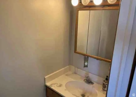 Vanity area featuring a light-colored countertop, integrated sink, and an overhead light fixture
