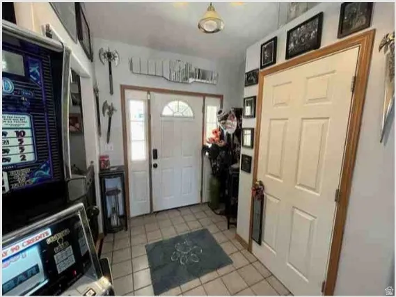 Entryway featuring a white paneled door with an arched transom window, a frosted glass sidelight, and ceramic tile flooring