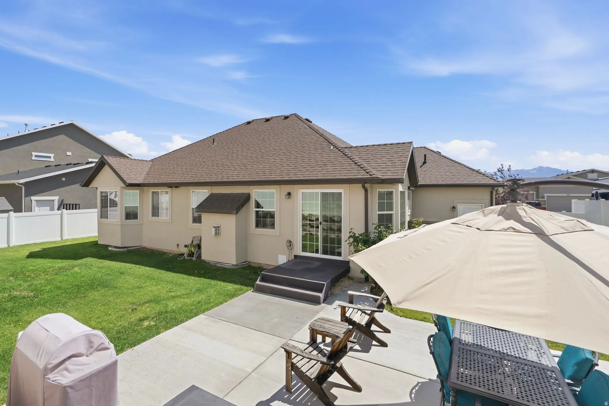 Rear exterior featuring stucco siding and a shingled roof