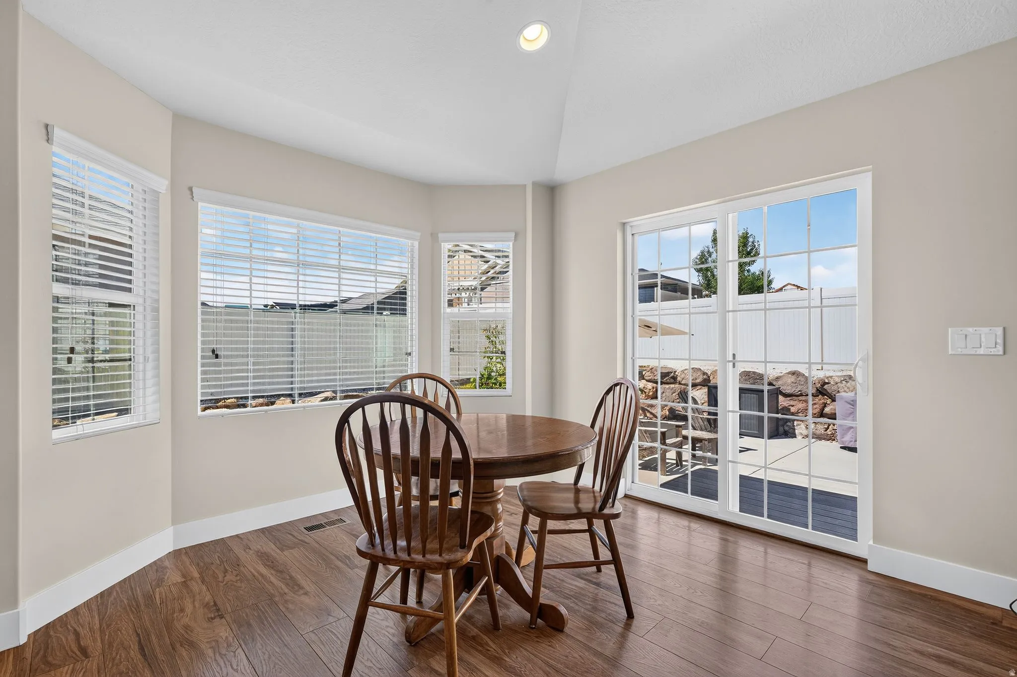Breakfast nook with wood-finish flooring, ample natural light, recessed ceiling lighting, and patio access via sliding glass doors