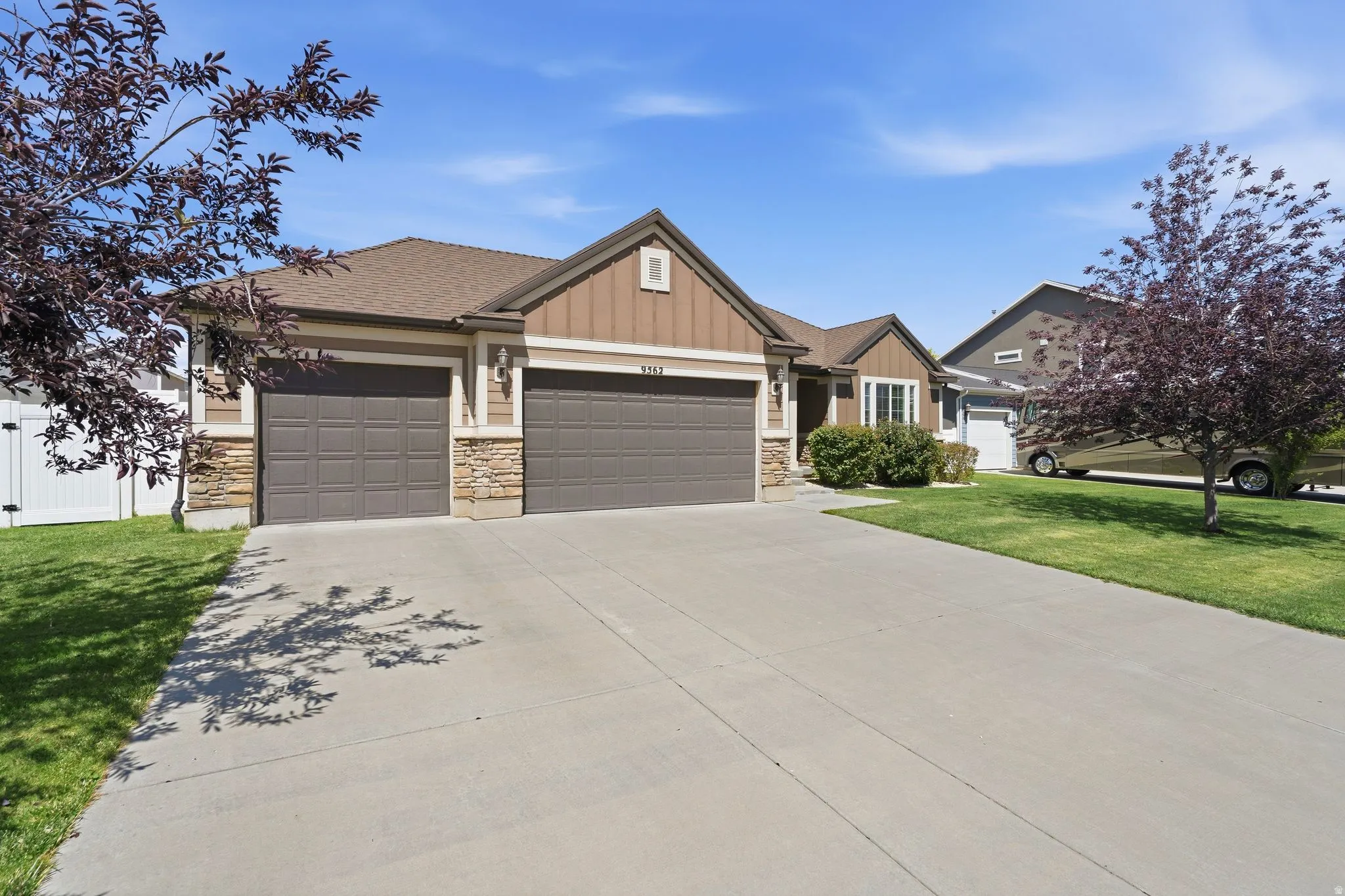 Ranch-style residence featuring a two-car garage, stone and siding facade, and a concrete driveway
