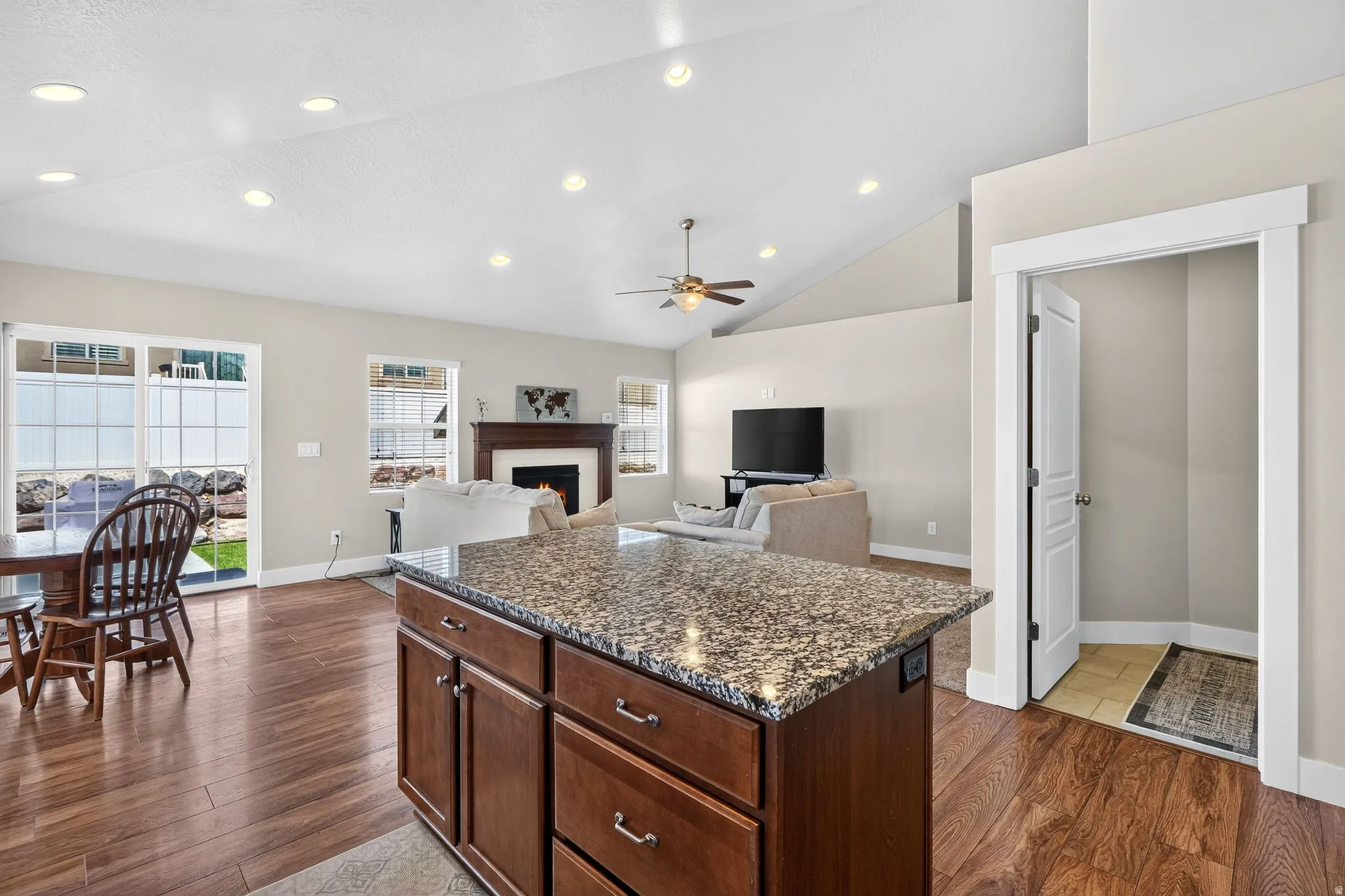 Kitchen island with a speckled countertop and rich wood-finish cabinetry