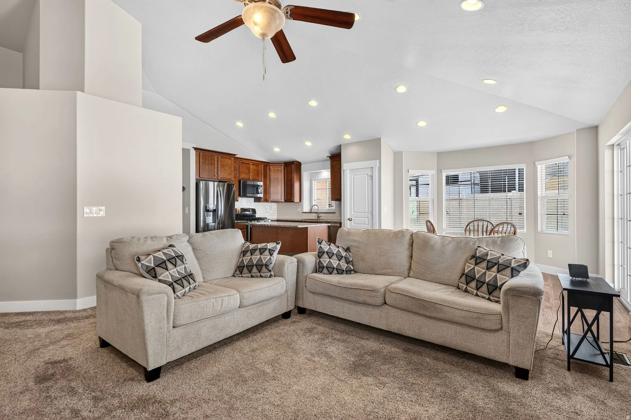 Vaulted ceilings with recessed lighting and a ceiling fan