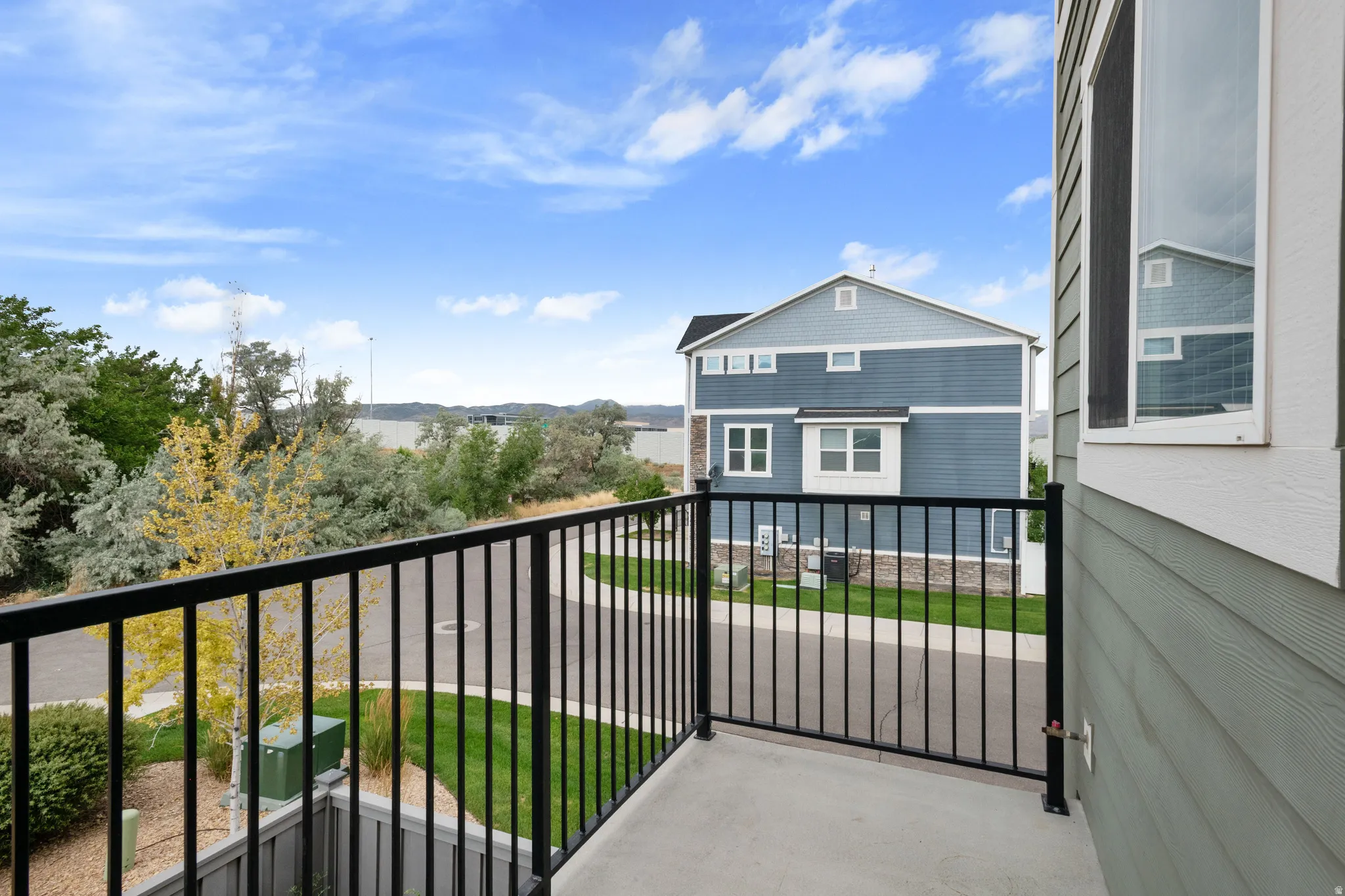 Outdoor balcony featuring a black metal railing and concrete flooring