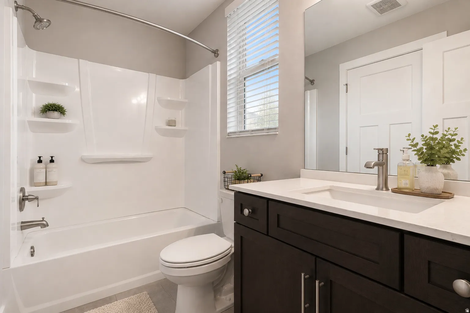 Bathroom featuring a dark wood-finish vanity with a white countertop and undermount sink