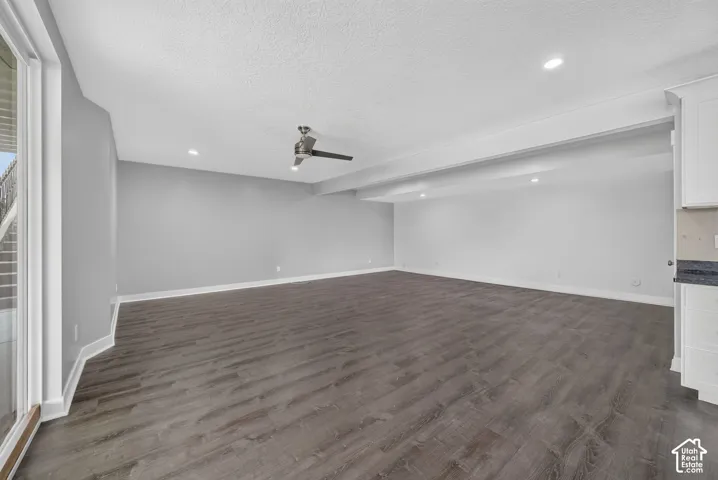 Spacious interior room featuring wood-finish flooring, recessed lighting, and a ceiling fan
