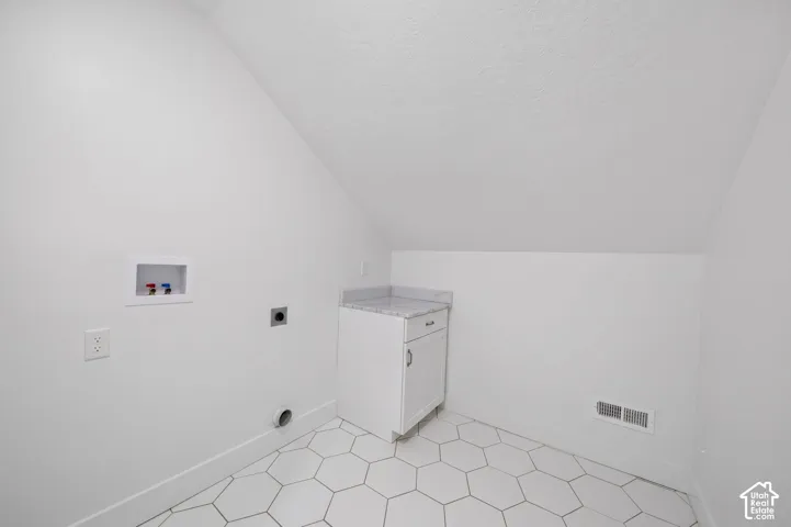 Utility area with hexagonal tile flooring and white baseboards