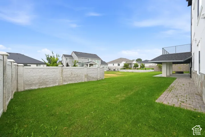 Expansive green lawn with a textured concrete perimeter fence
