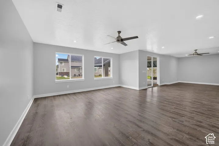 Spacious room featuring wood-finish flooring, light gray walls, and white baseboards
