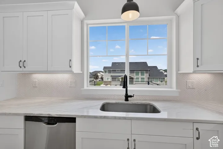 Kitchen features a stainless steel undermount sink with a matte black faucet, set within a light-toned countertop