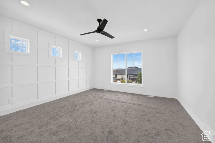 Spacious room featuring a large picture window, recessed lighting, and a modern ceiling fan