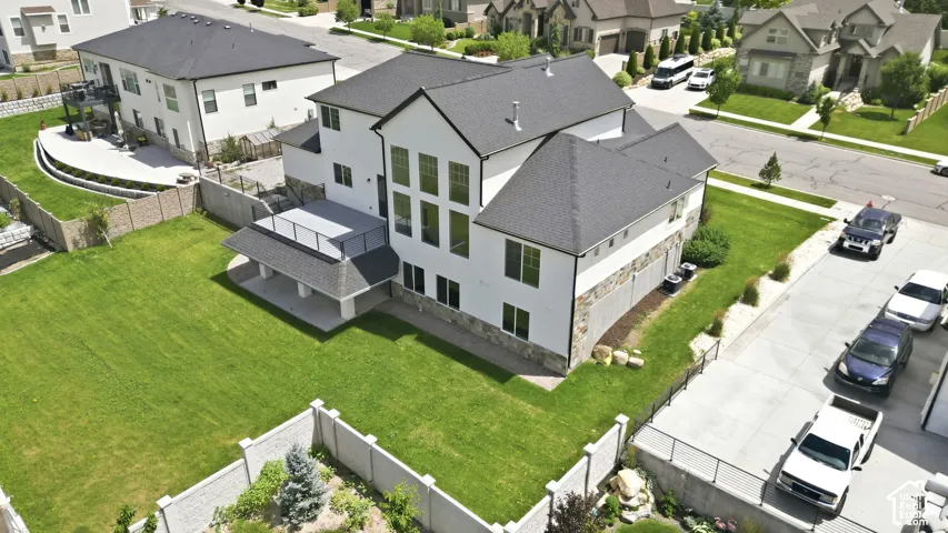Spacious backyard featuring a covered patio, an upper-level deck, and extensive lawn area