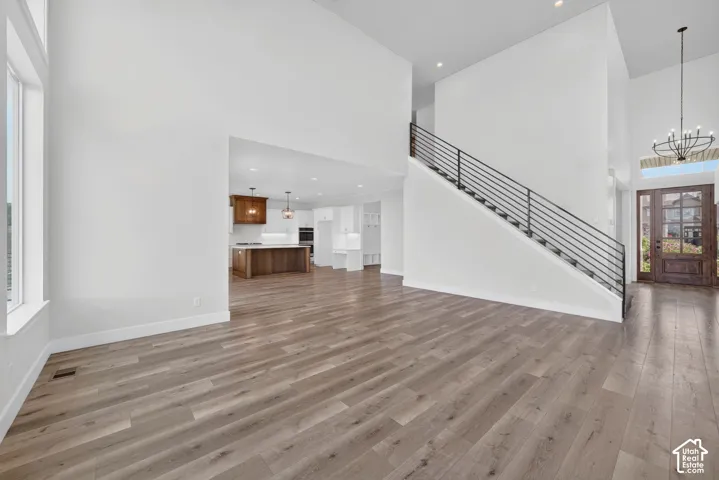 Spacious interior with wood-finish flooring and a contemporary staircase featuring black horizontal balusters