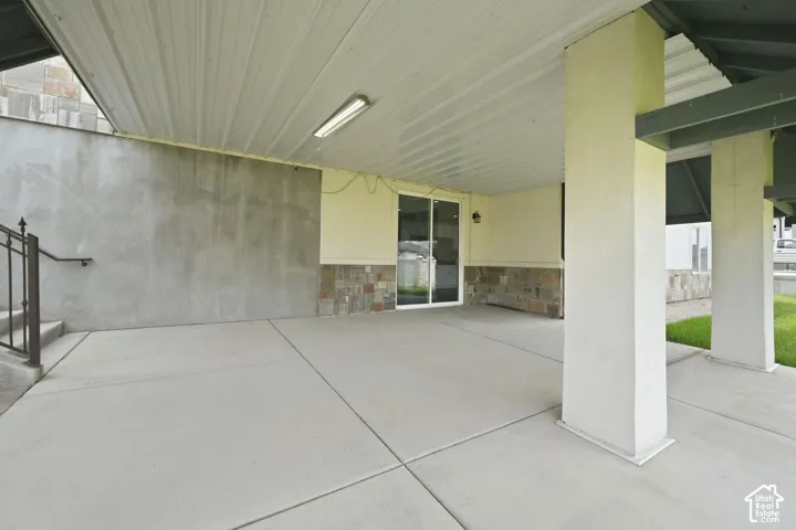 Expansive covered concrete patio featuring a metal ceiling, recessed lighting, and support columns