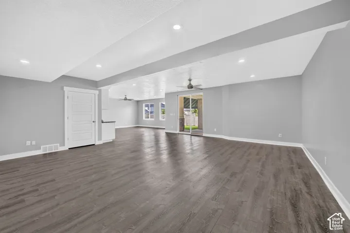 Spacious open-concept living area featuring wood-finish flooring and recessed lighting