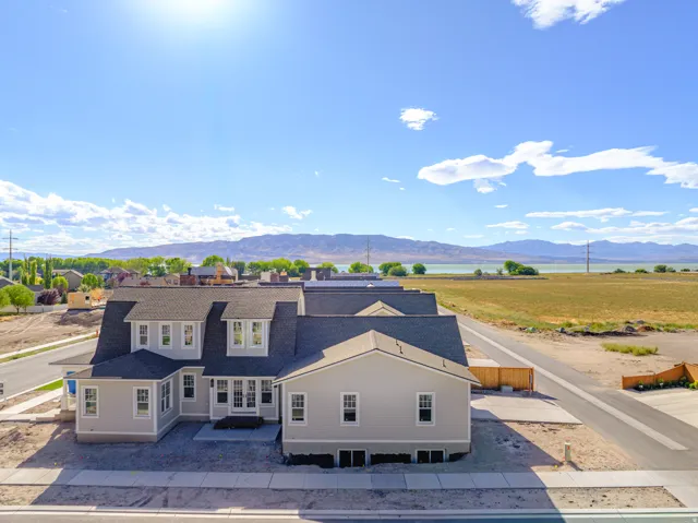 Contemporary residence featuring a multi-gable roofline, dormer windows, and light-colored siding
