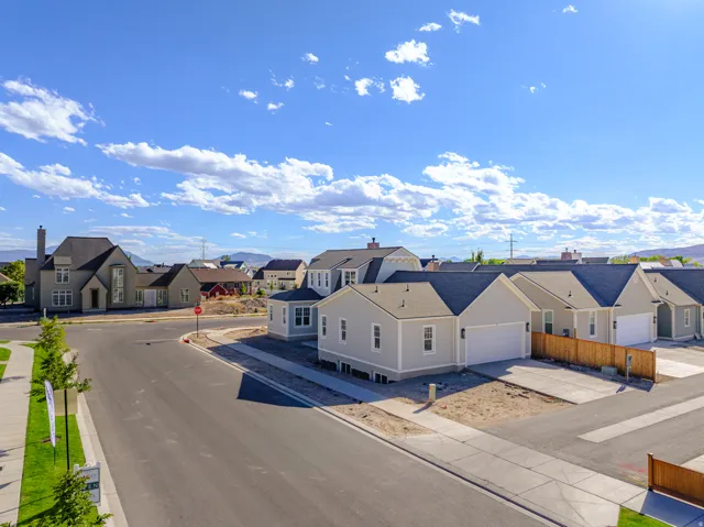 Newly constructed residences featuring light-colored siding, attached garages, and dark shingle roofs