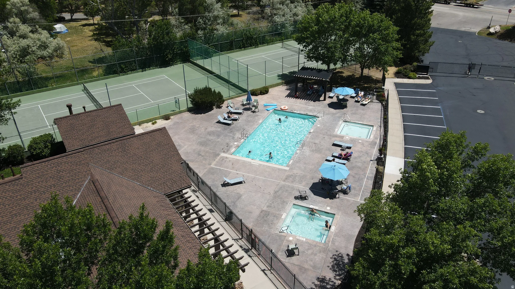 Outdoor recreational area featuring a swimming pool, two integrated spas, and a surrounding concrete deck